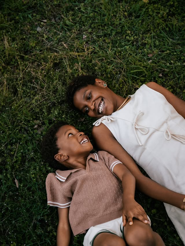 Mother and child laughing in the grass